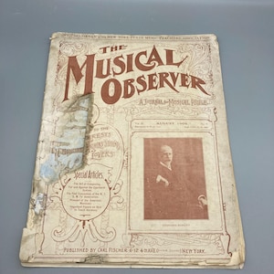 Puede incluir: Una copia antigua de "The Musical Observer", una revista para amantes de la música, de agosto de 1909. La portada es beige y marrón con el título en letras grandes. La portada también presenta un retrato de Edouard Schütt.
