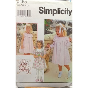 Puede incluir: Patrón de costura Simplicity para vestidos de niña. El patrón presenta ilustraciones de vestidos infantiles en rosa, con detalles como cuellos de encaje y cierres de botones. El paquete incluye el texto "Rare Editions" y el logotipo de Simplicity.