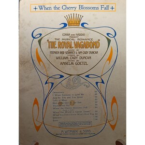 Puede incluir: Portada de partitura musical vintage para el romance musical "The Royal Vagabond". Presenta un diseño ornamentado con texto que incluye "When the Cherry Blossoms Fall" y los nombres de los autores. Incluye una lista de canciones.