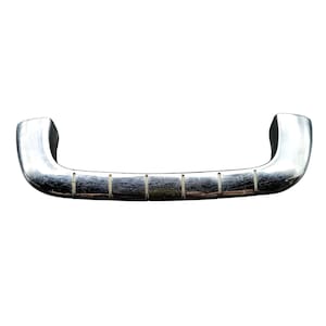 May include: A shiny, chrome-colored handle with a curved design. The handle has a series of rectangular indentations along its length. The ends of the handle are thicker and more rounded. The handle is likely for a cabinet or drawer.