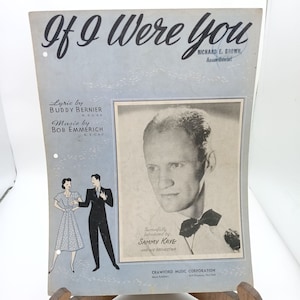 Może przedstawiać: Okładka vintage'owej partytury do piosenki "If I Were You" autorstwa Buddy'ego Berniera i Boba Emmericha. Na okładce znajduje się czarno-białe zdjęcie mężczyzny w muszce oraz mniejsza czarno-biała ilustracja tańczącej pary.