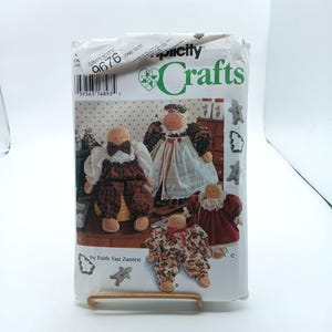 Puede incluir: Un patrón de costura Simplicity Crafts para hacer cuatro muñecas de tela. El patrón es para una familia de muñecas, que incluye una madre, un padre y dos hijos. El patrón está etiquetado como "9676" y es de talla única. El patrón es de Faith Van Zanten.