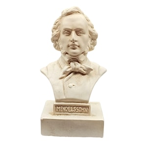 May include: A cream-colored bust of Felix Mendelssohn. The sculpture features a detailed depiction of the composer's face, hair, and attire, including a bow tie. The base of the bust has the name "MENDELSSOHN" in capital letters.