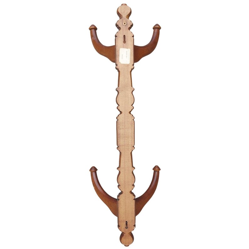 Pu&ograve; includere: Un attaccapanni da parete in legno con due serie di ganci curvi. L'attaccapanni ha un design verticale decorativo con un centro marrone chiaro e ganci marrone scuro. &Egrave; dotato di un buco della serratura per appenderlo.