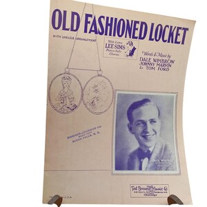 Może przedstawiać: Nuty zatytułowane "Old Fashioned Locket" z niebieskim tekstem. Nuty zawierają rysunek medalionu i portret uśmiechniętego mężczyzny. Nuty pochodzą od Ted Browne Music Co. w Chicago.
