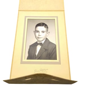Foto de retrato vintage en sobre de tarjeta de gabinete, original en blanco y negro de un joven elegante con el pelo partido y pajarita.