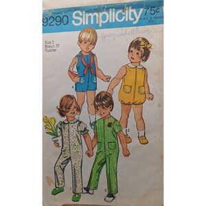 以下が含まれることがあります： 幼児サイズ3、胸囲56cm用のSimplicity 9290型紙封筒。イラストには、青いロンパース、黄色いロンパース、花柄のジャンプスーツ、緑のストライプのジャンプスーツなど、様々な服を着た4人の子供が描かれています。