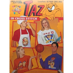 May include: A promotional image for a Taz cross-stitch pattern. The image features the word "TAZ" in large red letters, with the Taz character. The image also shows people wearing Taz-themed apparel, including t-shirts and a sweatshirt. The text "IN CROSS STITCH" is also visible.