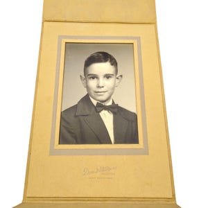 Foto de retrato vintage en sobre de tarjeta de gabinete, original en blanco y negro de un joven elegante con el pelo partido y pajarita.