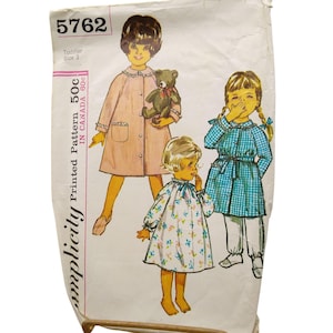 May include: Vintage Simplicity pattern 5762 for a toddler size 3. The pattern features illustrations of children in dresses and a coat. The pattern is printed in Canada and includes the price of 50c.