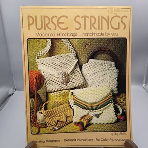 May include: A book titled "Purse Strings: Macrame Handbags... handmade by you." by Liz Miller. The cover features a close-up of four macrame handbags in various colors and styles.