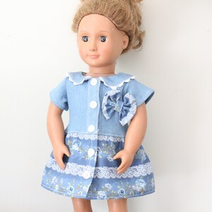 May include: A blue denim dress with a white collar and a floral print skirt. The dress has a bow on the front and white buttons.