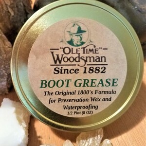 May include: A gold tin with a label that reads "Ole Time Woodsman Since 1882 Boot Grease The Original 1800's Formula for Preservation Wax and Waterproofing 1/2 Pint (8 OZ)"