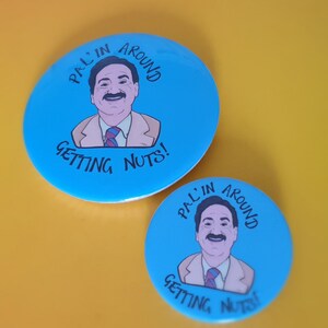 May include: Two blue and white round buttons with a cartoon image of a man with a moustache and the text "Pal'in Around Getting Nuts!"