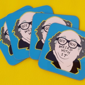 May include: Four blue square coasters featuring a cartoon image of a man with glasses and the text "Get Weird With It" on the glasses. The man has grey hair and a pink face.