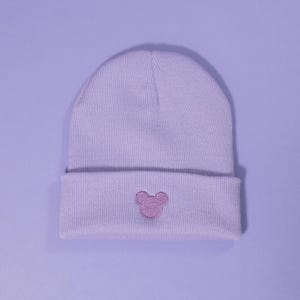 May include: A lavender beanie with a pink embroidered Mickey Mouse head on the front.