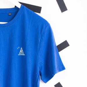 May include: A royal blue t-shirt with a small, embroidered design of a blue wizard hat with a crescent moon and stars on it.