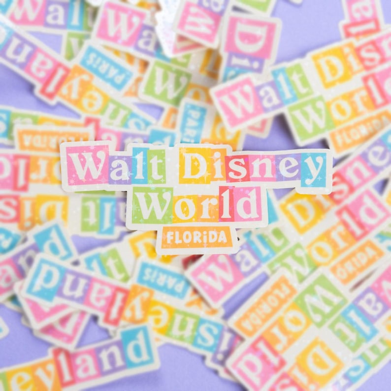 May include: A collection of colorful stickers featuring the Walt Disney World logo. The stickers are arranged in a random pattern on a purple background. The main sticker in the center reads "Walt Disney World Florida".