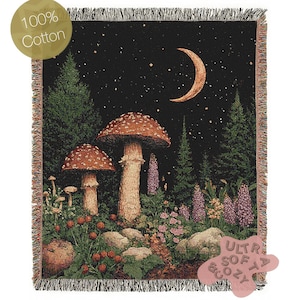 Puede incluir: Manta tejida con una escena de bosque con setas, una luna creciente y un cielo estrellado. La manta está hecha de 100% algodón y tiene un borde con flecos. Las palabras "Ultra Soft & Cozy" están impresas en la parte inferior derecha.