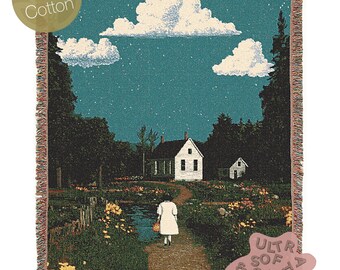 May include: A woven tapestry throw blanket featuring a night scene with a white house, trees, a pond, and a person walking on a path. The sky is blue with white clouds and stars. The text "Ultra Soft & Cozy" is in the lower right corner.