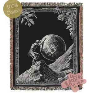 May include: Black and white tapestry featuring a man pushing a large sphere uphill. The tapestry has a black background with a decorative border. The text "100% Cotton" and "Ultra Soft Cozy" are visible in the image.