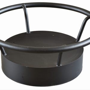 May include: Black metal fire pit ring with a round base and three vertical bars. The ring is designed to hold logs for a fire.