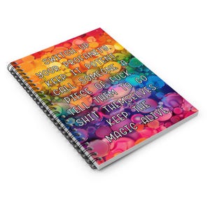 May include: A spiral-bound notebook with a colorful, abstract design. The cover features a rainbow gradient of colors and text that reads "SWITCH UP YOUR PROFANITY. KEEP IT POTENT... KEEP THE MAGIC ALIVE."