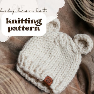 May include: White knitted baby bear hat with brown leather tag that says "Baby Knit Co."