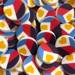 May include: A collection of colorful, round decorative items. Each item features a segmented design with red, blue, and purple sections, a white border, and a yellow heart. The items are scattered, creating a vibrant, eye-catching display.