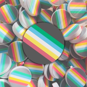 May include: A collection of gray, round polymer clay beads with a rainbow stripe design. The stripes include pink, yellow, white, blue, and green. The beads are a craft supply, perfect for jewelry making or other DIY projects.