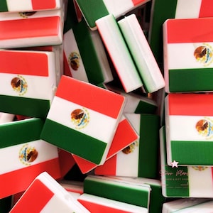 May include: A collection of square-shaped items, each featuring the Mexican flag design. The flags have a red top, white center with an emblem, and a green bottom. Some items are rectangular with the same color scheme.