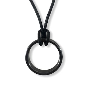 May include: A black ring pendant necklace with a black leather cord.