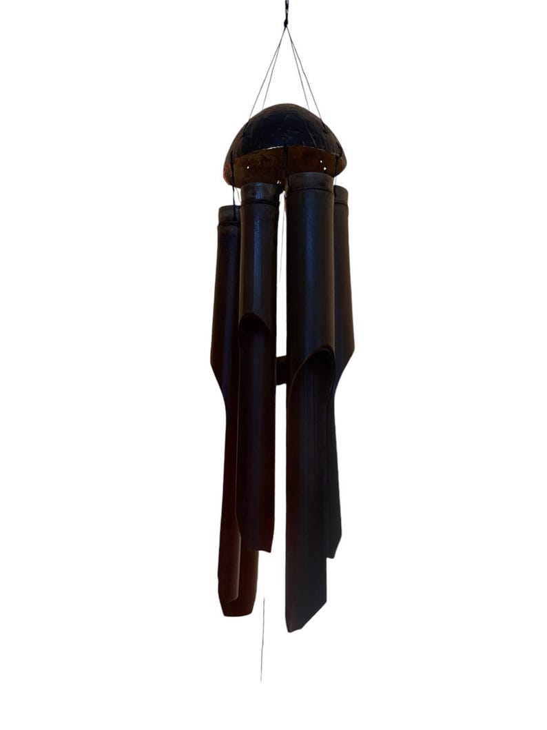 May include: A black bamboo wind chime with a round, dark brown top. The chime has five tubes of varying lengths.