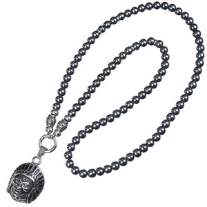 May include: A black hematite beaded necklace with a silver pendant featuring a detailed face with a headdress.
