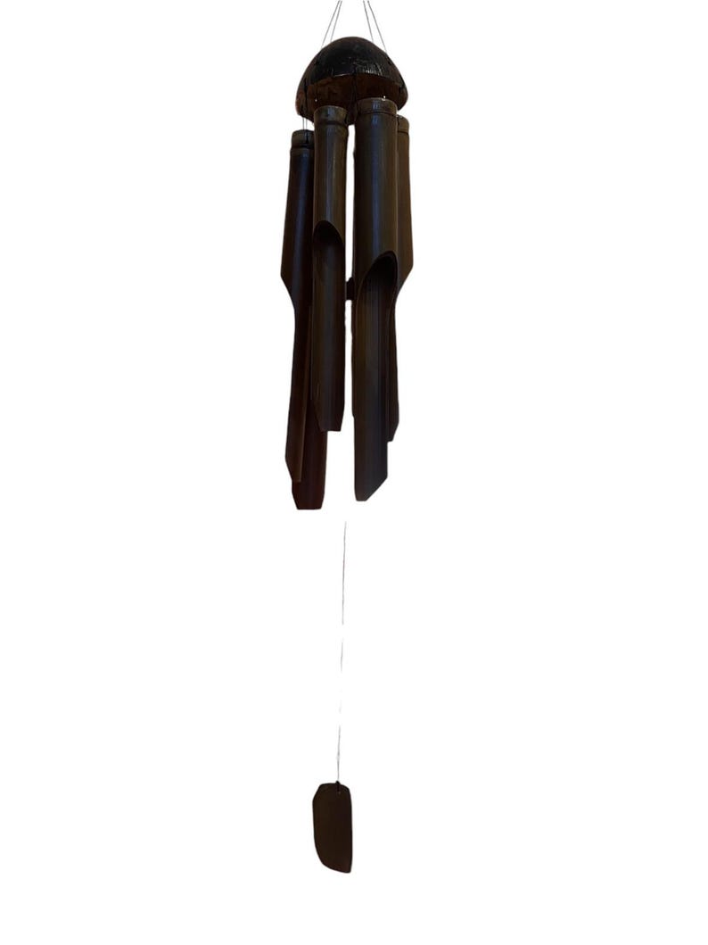 May include: A black bamboo wind chime with a wooden top and a long string hanging from it.