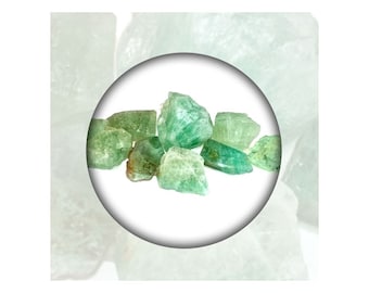May include: A close-up of a group of green and brown rough emerald crystals.
