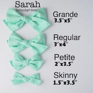 May include: Four mint green fabric hair bows in different sizes. The bows are labeled "Grande 3.5"x5", "Regular 3"x4", "Petite 2"x3.5", and "Skinny 1.5"x3.5".