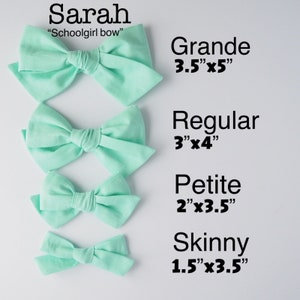 May include: Four mint green fabric hair bows in different sizes. The bows are labeled "Grande 3.5"x5", "Regular 3"x4", "Petite 2"x3.5", and "Skinny 1.5"x3.5".