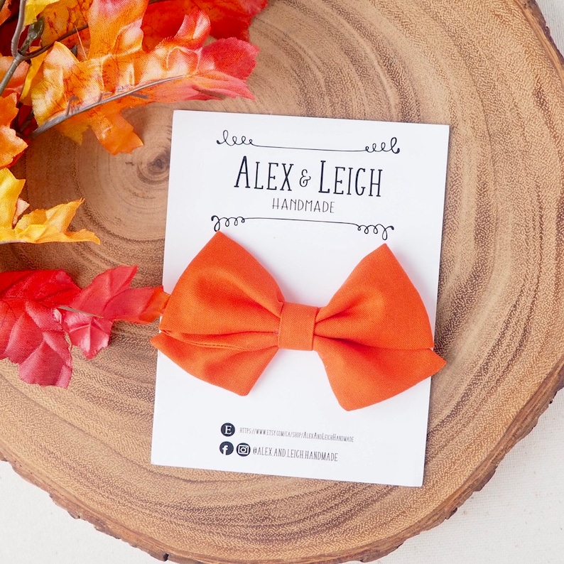 Pu&ograve; includere: Fazzoletto di stoffa arancione su una carta bianca con il testo "Alex & Leigh Handmade".