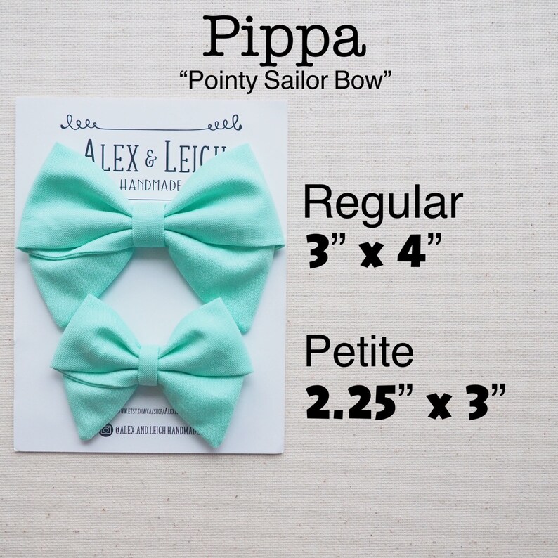 May include: Two aqua blue fabric hair bows, one larger and one smaller. The larger bow is 3 inches by 4 inches and the smaller bow is 2.25 inches by 3 inches. The bows are labeled "Pippa" and "Pointy Sailor Bow".