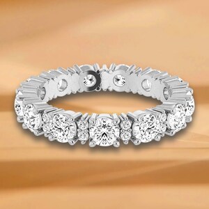 Könnte beinhalten: Ein silberner Ewigkeitsring mit einer Reihe runder, klarer Diamanten.