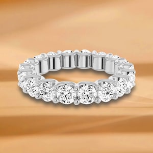 Könnte beinhalten: Ein silberner Ewigkeitsring mit einer Reihe runder, klarer Diamanten.