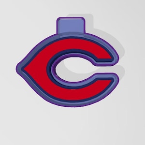 May include: A red and blue cookie cutter shaped like the letter "C" with a rounded top and bottom. The cutter is designed to create cookies in the shape of the Cleveland Indians logo.