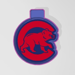 May include: A red and blue cookie cutter shaped like a bear inside a 'C'.