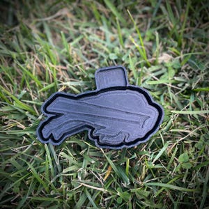 May include: A black plastic cookie cutter shaped like a football helmet.