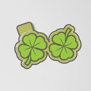 May include: A green four-leaf clover design with a light green outline and a light green background. The clover is a symbol of good luck and is often associated with St. Patrick's Day.