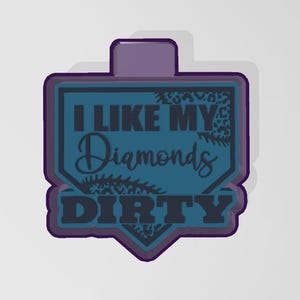 Puede incluir: Un cortador de galletas con forma de béisbol azul y morado con el texto "Me gustan mis diamantes sucios".