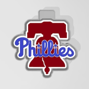 May include: A red Liberty Bell with two white stars and the word "Phillies" in blue script.