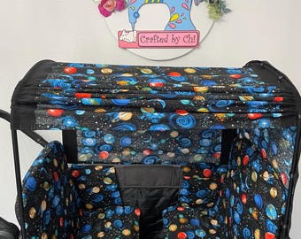 Könnte beinhalten: Ein schwarzer Wagen mit Verdeck und Innenstoff mit einem farbenfrohen Weltraum-Themenmuster aus Planeten, Sternen und Galaxien. Der Wagen hat eine graue Außenseite mit einer Vordertasche. Der Text "Crafted by Chi" ist sichtbar.