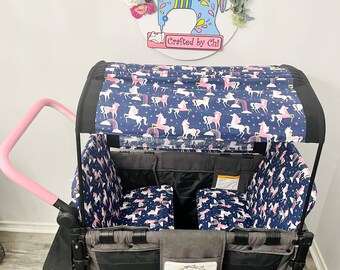 May include: A black wagon with a pink handle and a blue and pink unicorn print canopy. The wagon has two seats and a storage compartment. The wagon is decorated with a floral wreath and a sewing machine with the text "Crafted by Chi" on it.